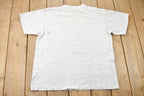 Vintage 1988 Bass Ackwards Fish Ray Troll Graphic T-Shirt