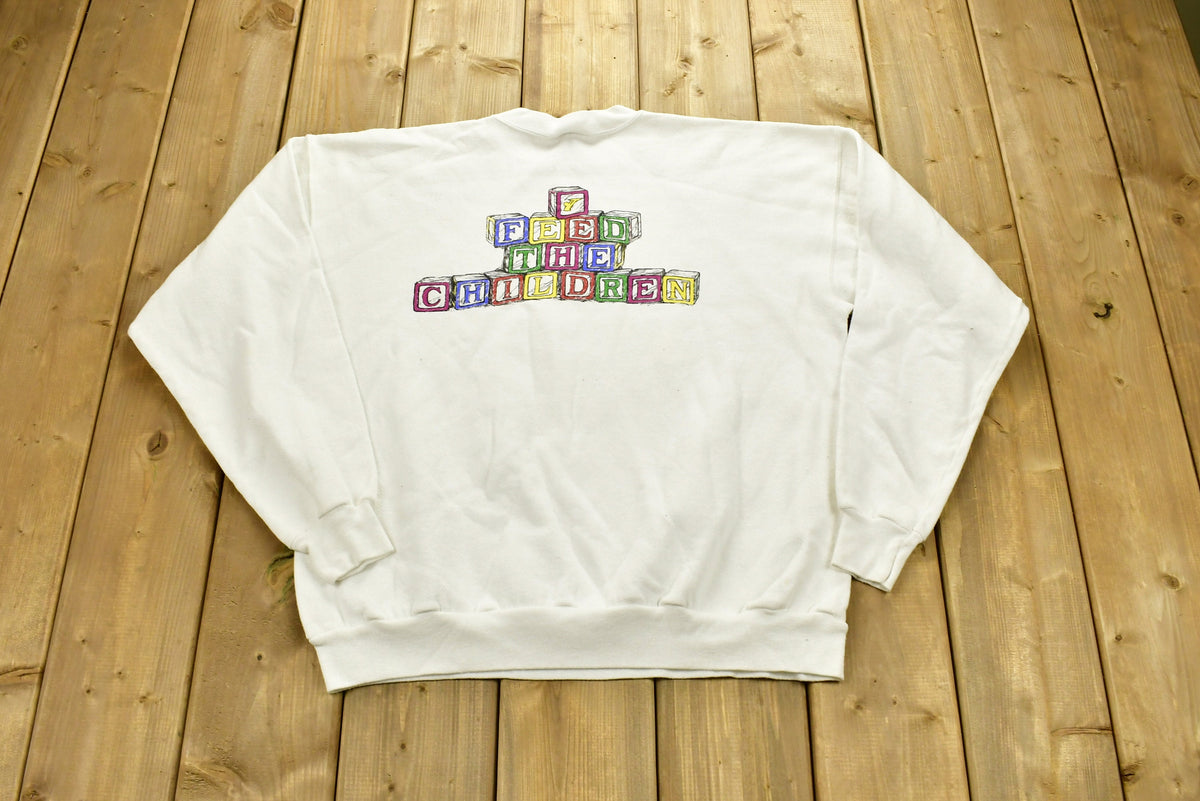 Vintage 1990s "Feed The Children" Graphic Christmas Sweater , 90s Holiday Crewneck , Winter Wear , Festive Graphic Print